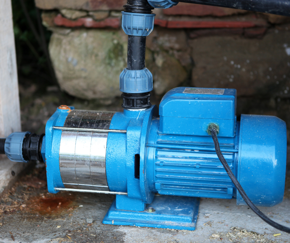 A blue water pump installed outdoors with connected piping.